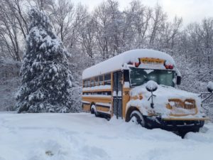 Autobus scolaire jaune enseveli sous la neige.